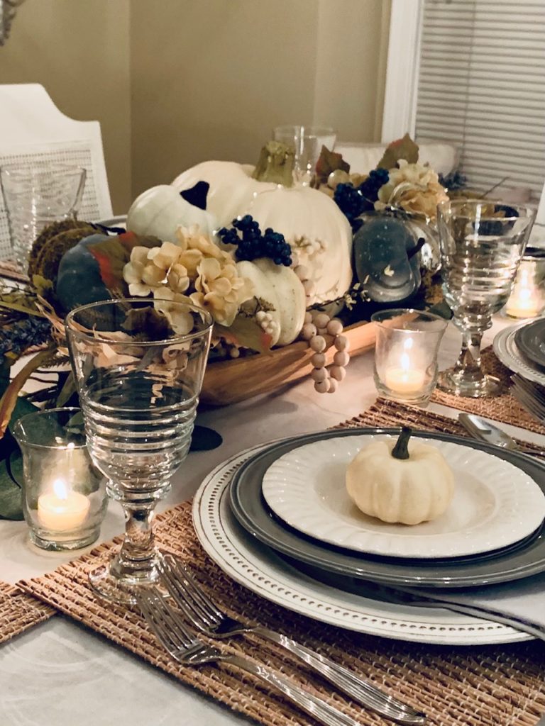 A fall table scape using blues, creams, with pumpkins
