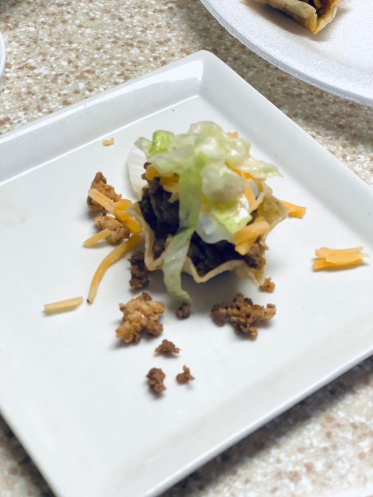 Adding lettuce to the mini taco