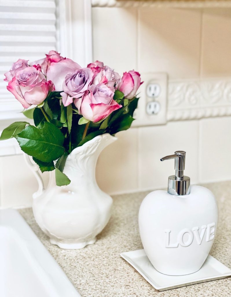 Pink roses in a white ceramic pouring pitcher