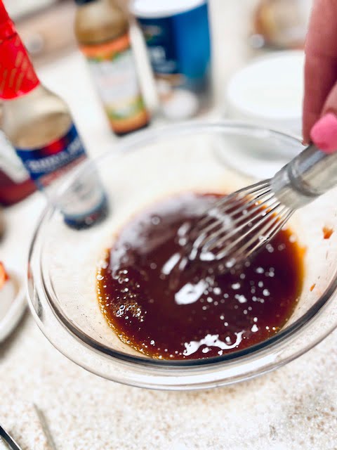 Whisking Sauce ingredients together in a bowl with a whisk