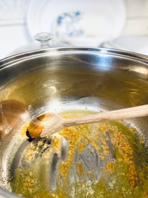 Adding garlic and onion to the stock pot with olive oil