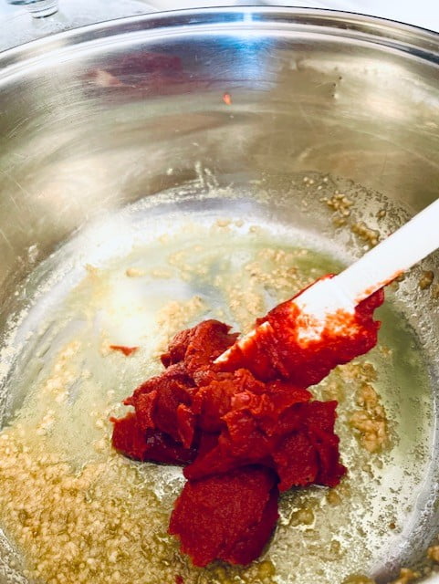 Adding tomato paste to the stock pot