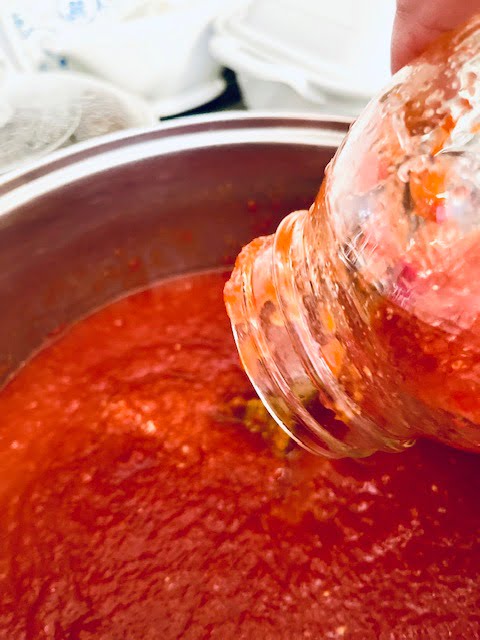 Pouring the canned tomatos into the stock pot