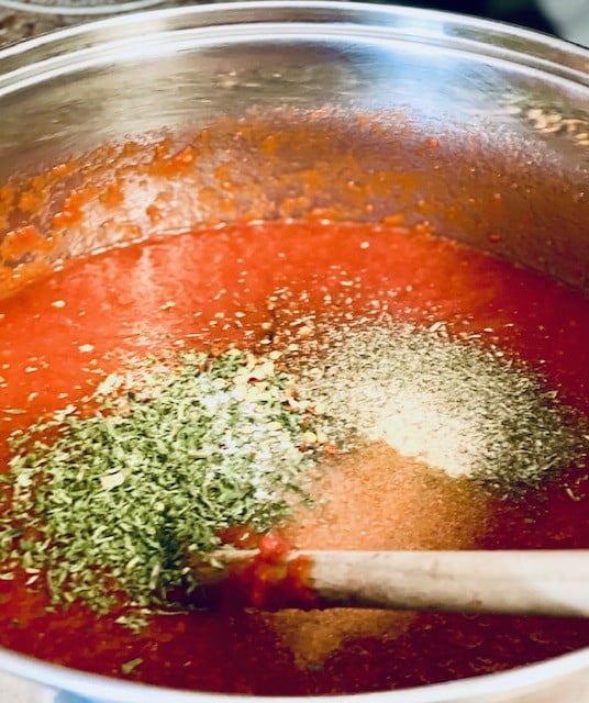 Adding all the seasoning to the sauce in the stock pot
