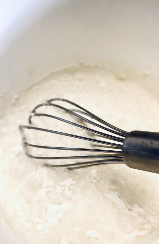 Whisking the milk and flour together 