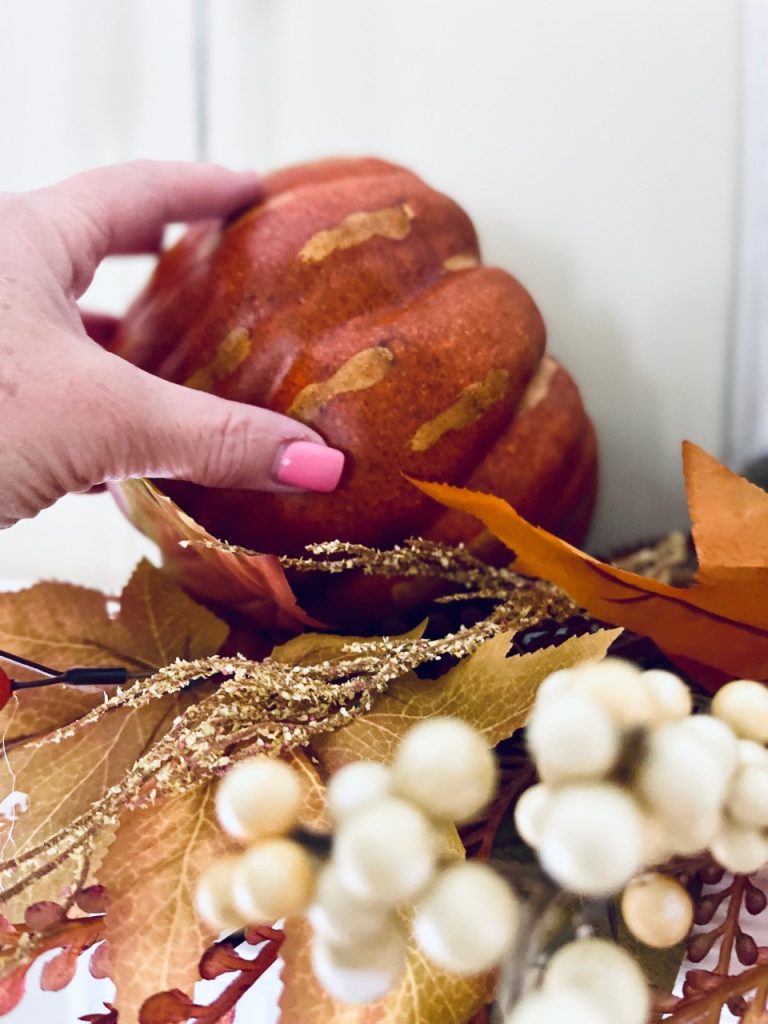 Placing a fall pumpkin on a mantel