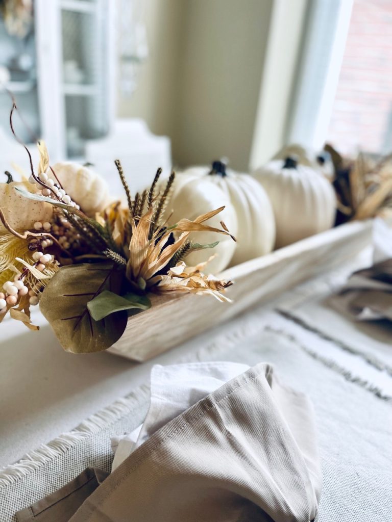 Dough bowl with faux flowers on the table 