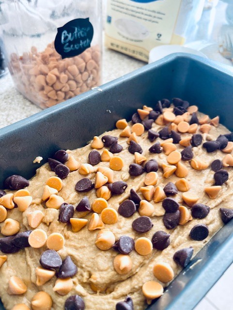 Adding chocolate and butterscotch chips to the top of the pumpkin mixture