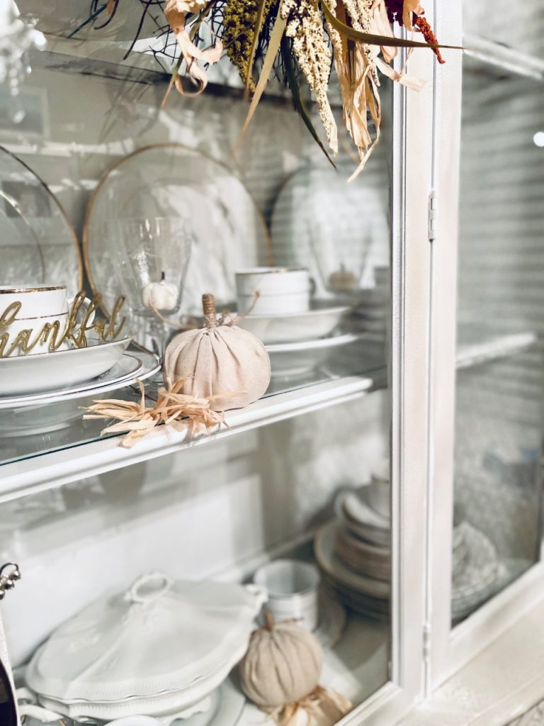 China cabinet decorated with fall pumpkins