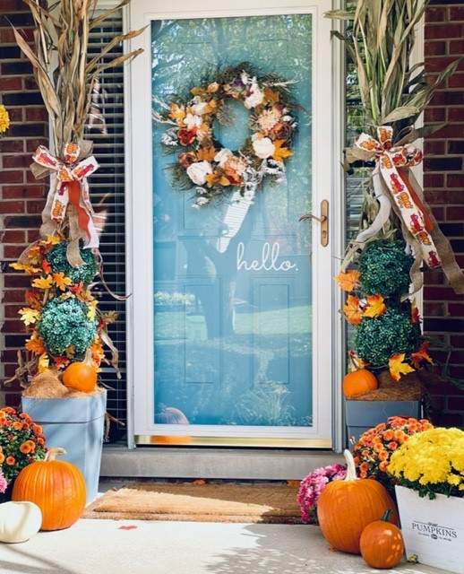 A picture of the porch all decorated for fall with all the ideas of mums and pumpkins