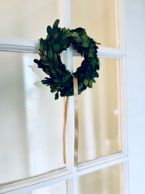 Placing a winter wreath with ribbon on a door