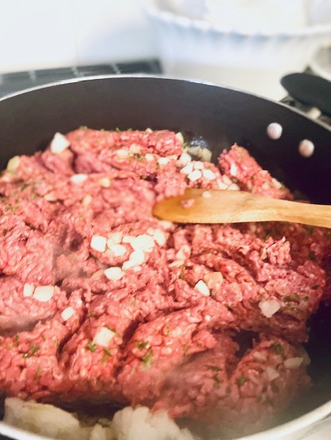 Mixing the hamburger and onion for This is the Easiest Gluten Free Sheppard's Pie Recipe