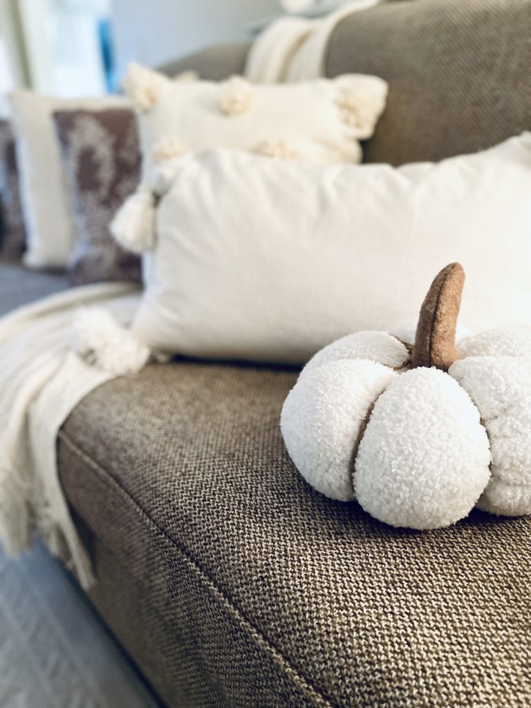 7 Inexpensive Fall Decorating Ideas by adding a pumpkin pillow